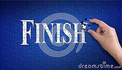 Finish word on Jigsaw puzzle. Man hand holding a blue puzzle to Stock Photo